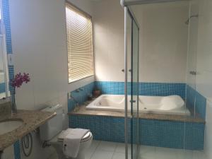 a bathroom with a tub and a toilet and a sink at Valparaiso Hotel in Cruz das Almas