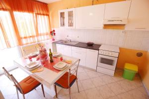 a kitchen with a table and chairs and a sink at Apartment Angela in Zadar +11 photos