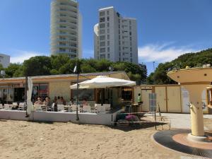 a restaurant with an umbrella on the beach with buildings at Residence Torre Zanier in Lignano Sabbiadoro