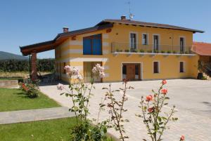 una gran casa amarilla con flores delante en Agriturismo Fior Di Campo, en Dronero