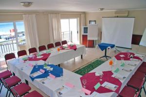 a conference room with tables and chairs and a screen at Chapman Hotel and Conference Centre in Port Elizabeth