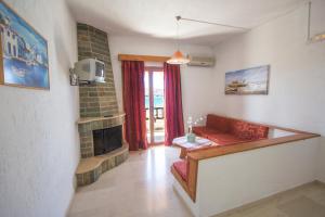 a living room with a red couch and a fireplace at Bay View Apartments in Sitia