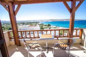 a balcony with a table and chairs and the ocean at Bay View Apartments in Sitia