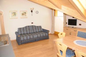 ein Wohnzimmer mit Couch und Tisch in der Unterkunft Residence Ciasa Dl Mone in Kolfuschg