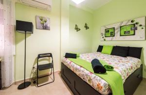 ein Schlafzimmer mit einem Bett mit einer grünen Wand in der Unterkunft Apartamentos Madrid XXXIII - Alojamiento de Temporada in Madrid