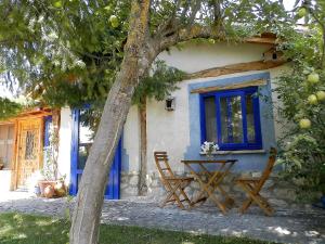 a house with a blue window and a table and chairs at Estudio rural Estrella Polar III in Huerta