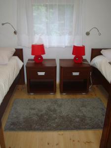 two nightstands with lamps on them in a bedroom at Domki Zacisze in Ustka
