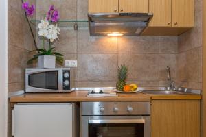 a small kitchen with a microwave and a sink at Apartment and Rooms Stay in Dubrovnik