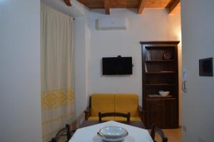 una habitación con una mesa y una silla y un televisor en Casa Vacanze La Pavoncella, en Iglesias