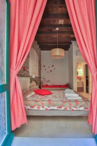 1 dormitorio con 1 cama grande y cortinas rojas en Mare amore @ Riomaggiore, en Riomaggiore