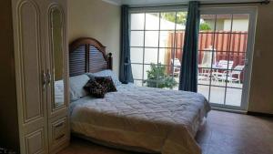 a bedroom with a large bed and a sliding glass door at Sandpiper Beach Apartments in Palm-Eagle Beach