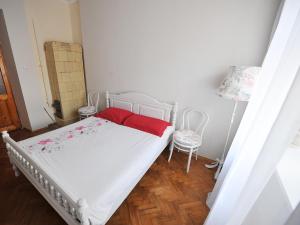 リヴィウにあるApartment - Lesi Ukrainky Streetのベッドルーム1室(白いベッド1台、赤いシーツ、椅子2脚付)
