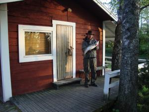 een man op de veranda van een hut bij Purolomat in Merikarvia