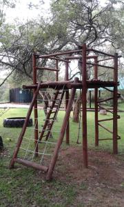 un parque infantil de madera con columpios en Blyde River Cabins, en Hoedspruit