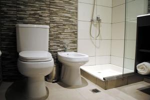 a bathroom with a toilet and a shower and a sink at Darwin Apart Hotel in Salta +19 photos