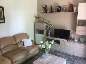 sala de estar con sofá y TV en Casa Elena, en Albisola Superiore
