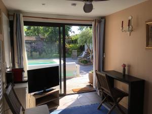 un soggiorno con televisione e porta scorrevole in vetro di La Casa Bonita a Martignas-sur-Jalle