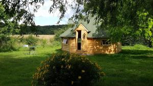 a small log cabin in the middle of a yard at La Bercéenne in Jupilles