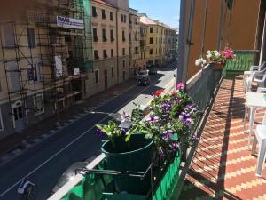 a balcony with flowers on a city street at Casa Elena in Albisola Superiore