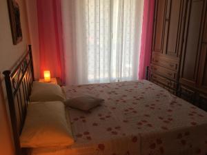 1 dormitorio con cama y ventana con colcha en Casa Elena, en Albisola Superiore