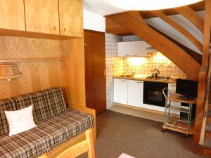 Il comprend un salon avec un canapé et une cuisine. dans l'établissement Residence Chris Appart, à Carezza al Lago