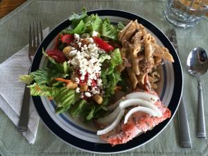 um prato de comida com salada e carne em Caribou Lodge Alaska em Talkeetna