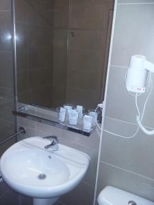 a bathroom with a sink and a mirror and a toilet at Hostal Rural San Andrés in Torres del Río