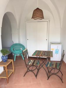 Cette chambre comprend deux chaises, une table et un réfrigérateur. dans l'établissement Studio Alli, à Pantelleria