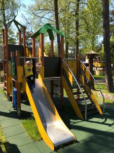 a child on a slide at a playground at Ameba Resort in Mielno