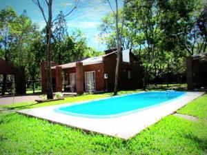 a large blue swimming pool in front of a house at Cabañas Punta Fabiana in Resistencia
