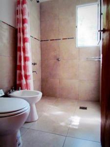 a bathroom with a shower and a toilet and a sink at Cabañas Punta Fabiana in Resistencia