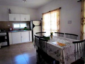 a kitchen with a table and chairs and a kitchen with a refrigerator at Cabañas Punta Fabiana in Resistencia
