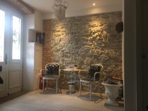 een eetkamer met een stenen muur en een tafel en stoelen bij ROMANTIC APARTMENT Lovran - 4 stars in Lovran