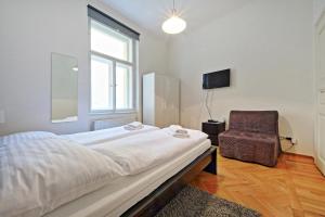 プラハにあるButch Apartmentのベッドルーム1室(ベッド1台、椅子、窓付)