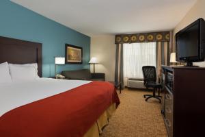 a hotel room with a bed and a flat screen tv at Holiday Inn Express Winston-Salem, an IHG Hotel in Winston-Salem