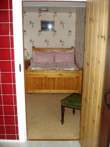 um pequeno quarto com uma cama e uma cadeira em The Clochfaen em Llangurig