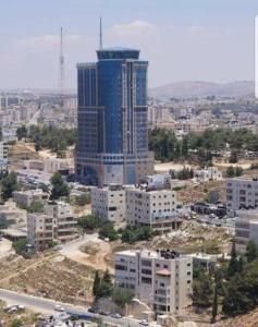 an aerial view of a city with a tall building at Palestine Plaza Hotel in Ramallah
