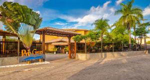 a resort with a palm tree and a building at Porto Geraes Praia Hotel in Porto Seguro