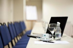 a table with a bottle of water and a glass at Celi Hotel Aracaju in Aracaju +25 photos