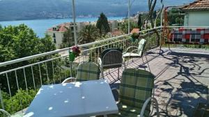 a table and chairs on a balcony with a view of the water at House Orange Apartments in Herceg-Novi