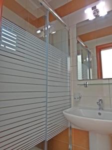 a bathroom with a glass shower and a sink at Pioneer Excelsior Rooms in Paralia Katerinis