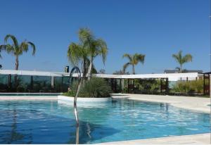 a swimming pool with a fountain in front of a building at Mayim Hotel Termal & Spa in Concordia