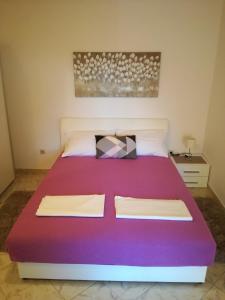 1 dormitorio con 1 cama grande con sábanas moradas en Apartments Lili, en Zadar