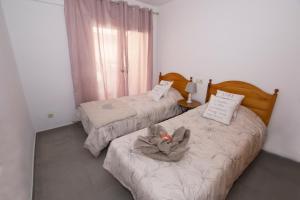 twee bedden in een slaapkamer met een knuffeldier erop bij Apartamento playas calpe in Calpe