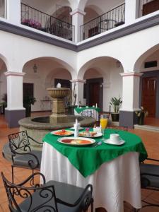 a table with a green table cloth and a fountain at Hotel del Marquesado in Oaxaca City
