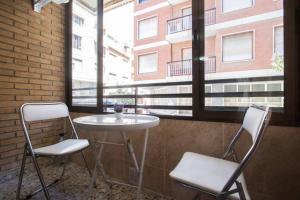 two chairs and a table in front of a window at Poeta Campos Vasallo 19 in Alicante