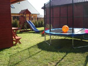 a playground with a slide and a play structure at Ośrodek Wypoczynkowy "Słoneczko" in Rusinowo