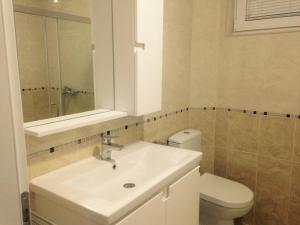 a white bathroom with a sink and a toilet at Vila Mare in Ohrid