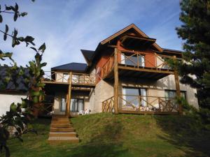 une maison sur une colline avec des escaliers menant à elle dans l'établissement Miralagos Apart & Cabañas, à Villa Pehuenia