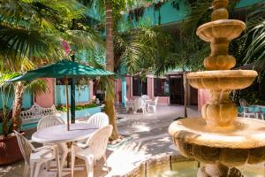 a fountain with chairs and a table with an umbrella at Hotel Acuario in Ciudad del Carmen